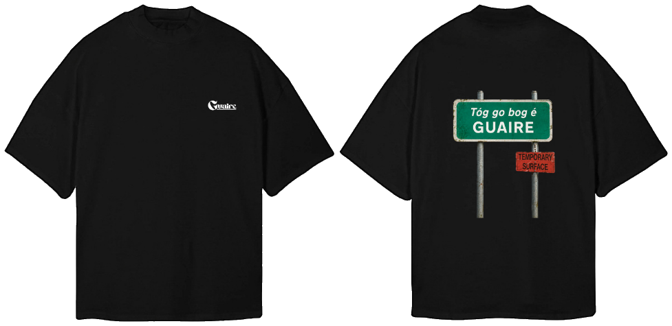 Black oversized tee, front and back: a small white Guaire logo on the chest and a green Irish road sign reading 'Tóg go bog é, GUAIRE' with a red 'Temporary surface' plate across the back.